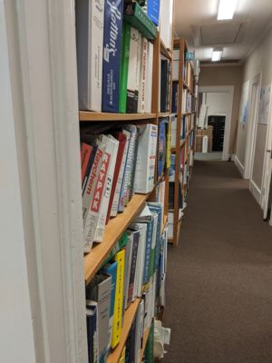 A tightly packed bookshelf is a significant RF obstacle,—worth a couple of walls in its own right—even when traversed perpendicularly. Penetrating its <em>length</em> is an absolute no-go.