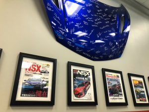 A signed car hood and framed photos on a wall
