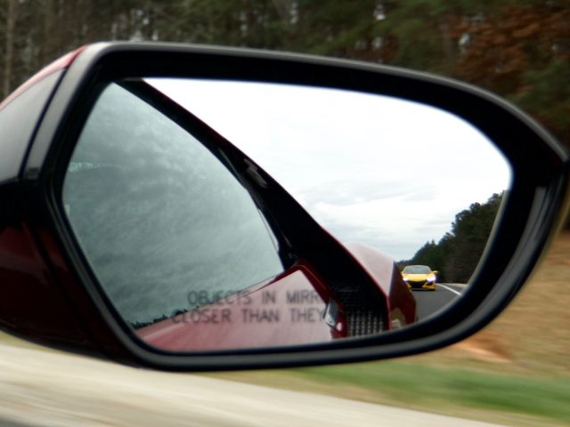 A yellow NSX seen in the mirror of a red NSX