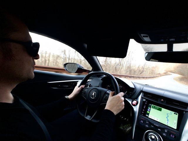 A man drives an NSX on a twisty road.