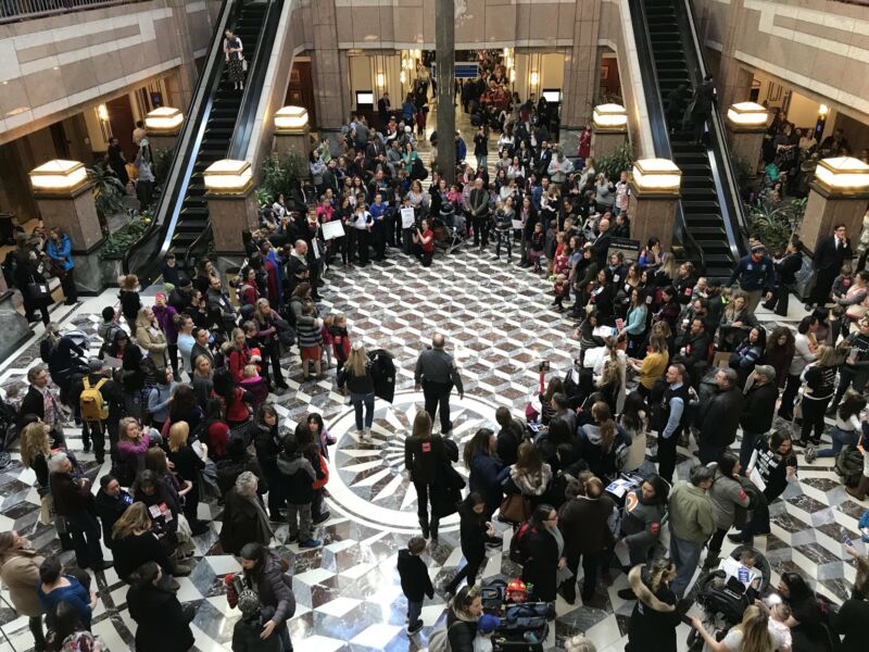 Image of anti-vaccine protestors in Connecticut's Legislative Office Building. They formed a prayer circle and said the Pledge of Allegiance and the Our Father before chanting “Healthy kids belong in school.”