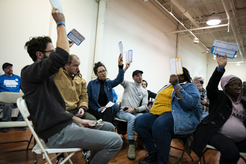 Voters hold up presidential preference cards during the first-in-the-nation Iowa caucus at the Southridge Mall in Des Moines.