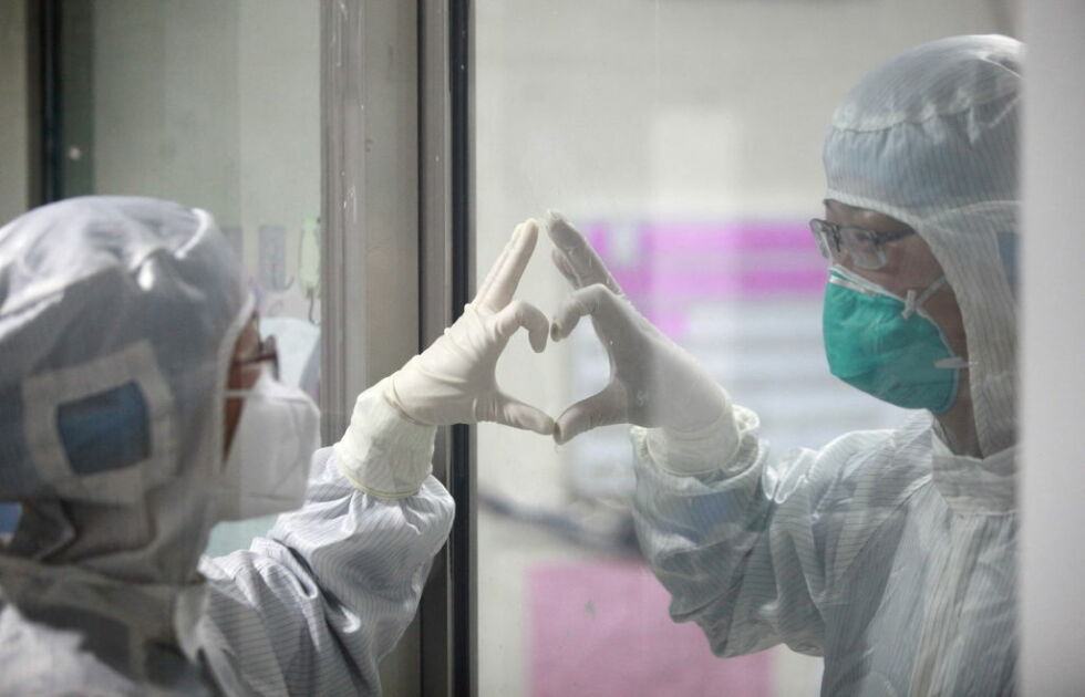YANGZHOU, CHINA - On Valentine's day, in a isolation ward novel coronavirus pneumonia in Yangzhou Third People's Hospital, a couple of doctors make gesture of love through glass. 