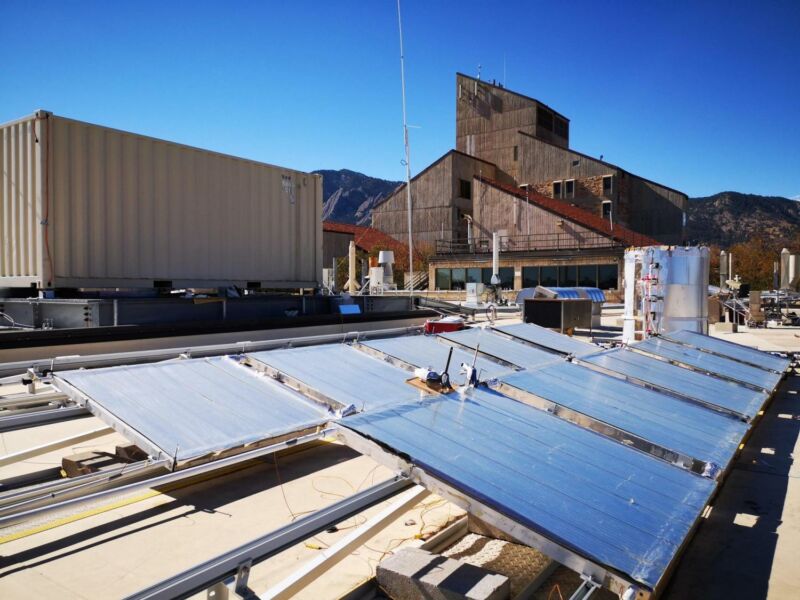 Image of grey panels in front of brown buildings.