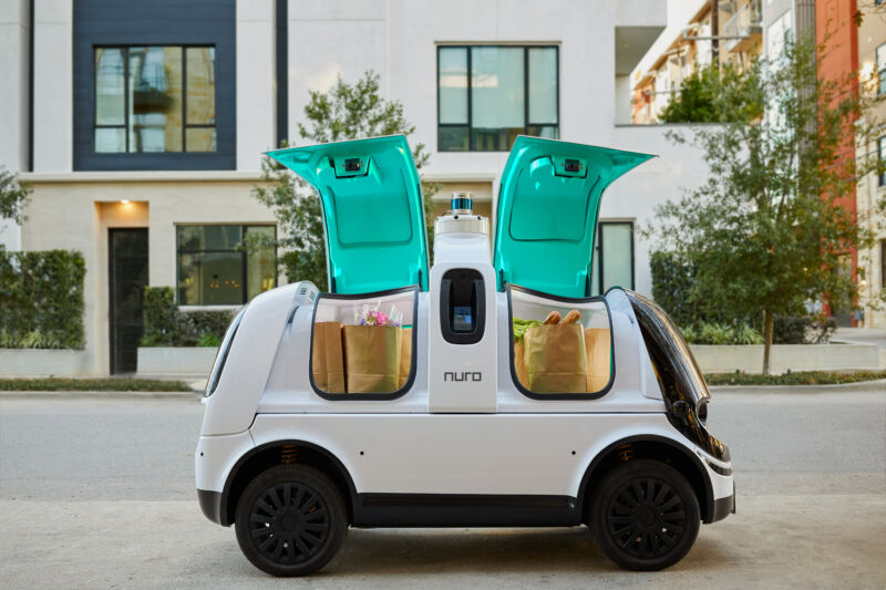 Promotional image of a self-driving, no-passenger vehicle on a sedate urban street.