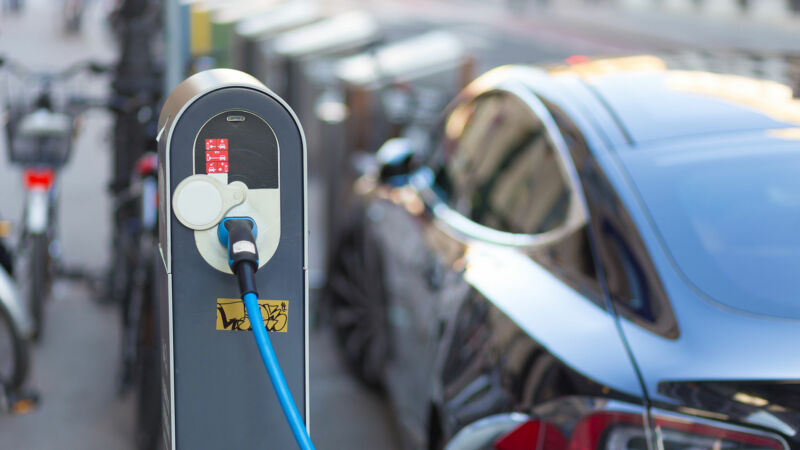 Image of a car plugged into charging hardware.