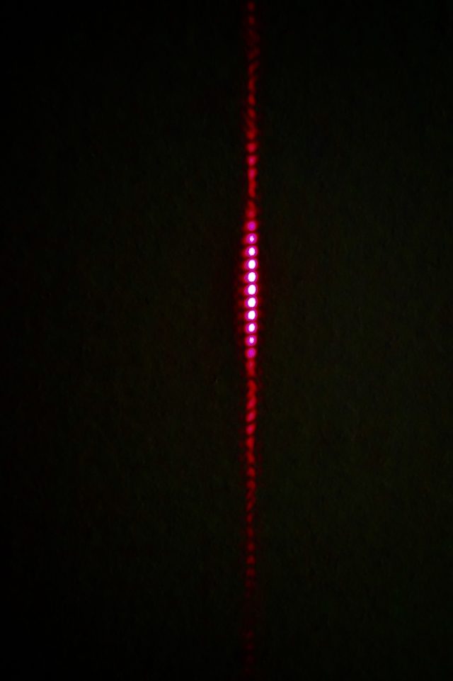 Laser light passing through the two horizontal slits produces the distinctive stripes of quantum mechanics.