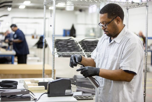 Operators and assemblers assemble medical face shields. Ford is aiming to produce 100,000 plastic face shields per week.