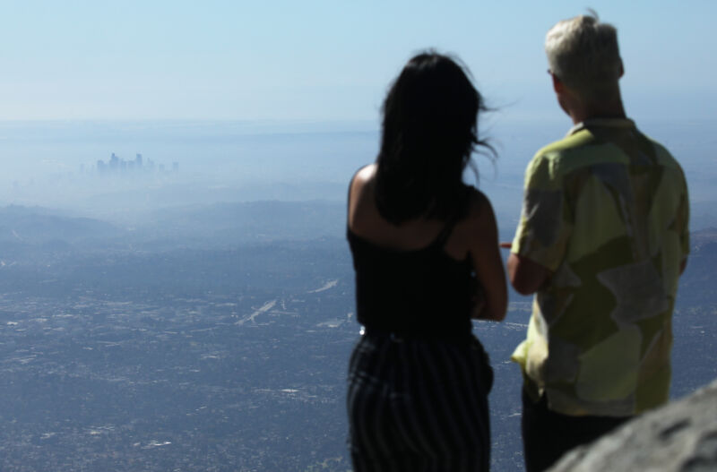 A man and a woman, properly socially distanced from the rest of Los Angeles, take in a view of the city on a low air quality day in November, 2019.