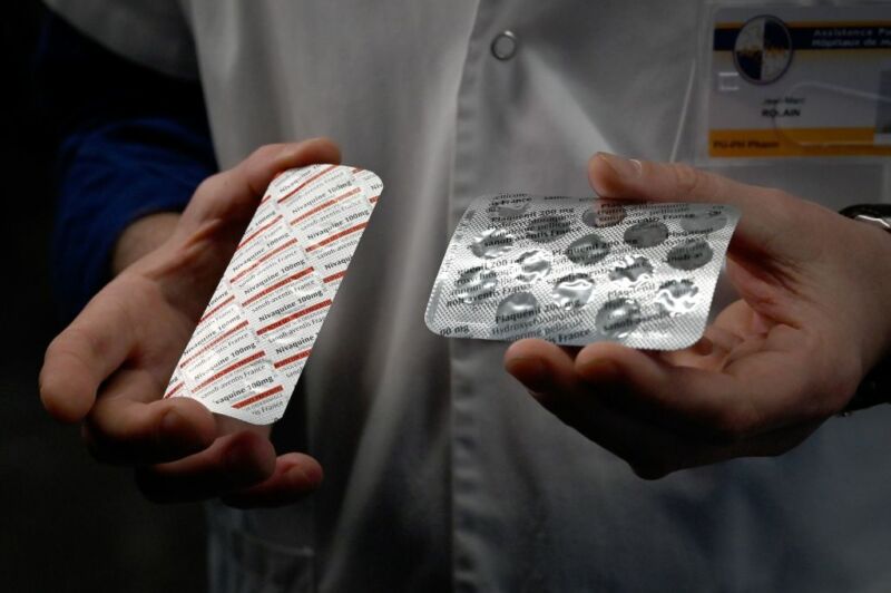 Image of a person's hands holding pill packaging.