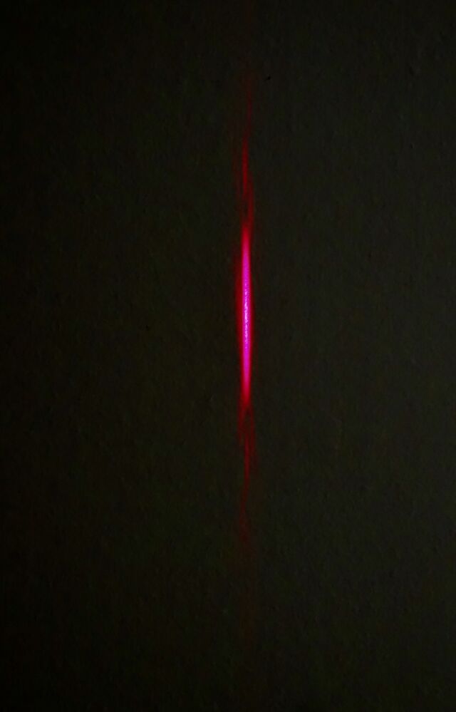 Laser light passing through the single horizontal slit is spread vertically