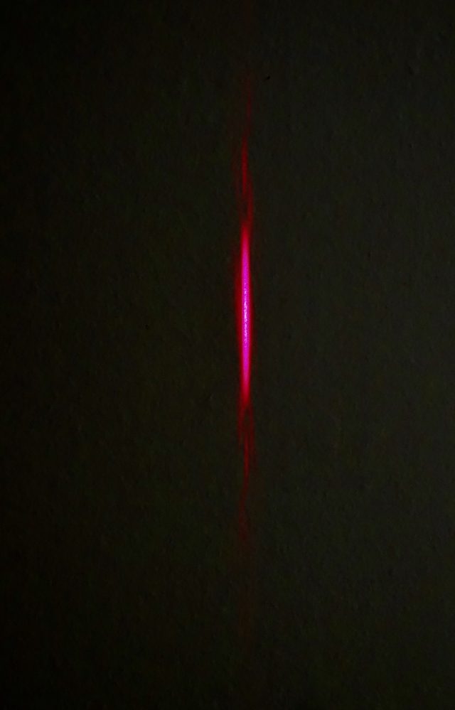 Laser light passing through the single horizontal slot is distributed vertically