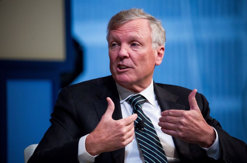 Charter CEO Tom Rutledge gestures with his hands and speaks at a conference.