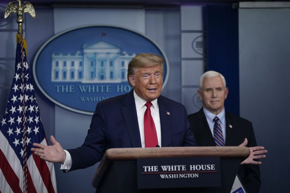 President Donald Trump speaks as Vice President Mike Pence looks on during a briefing on the coronavirus pandemic at the White House on March 26, 2020.