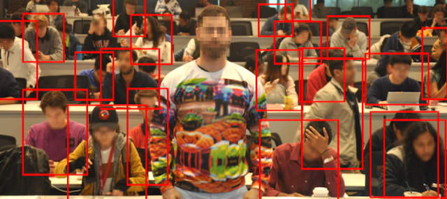 The bright adversarial pattern, which a human viewer can darn-near see from space, renders the wearer invisible to the software looking at him.