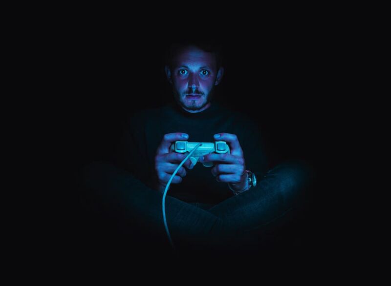 Stock photo of a man playing video games in the dark.