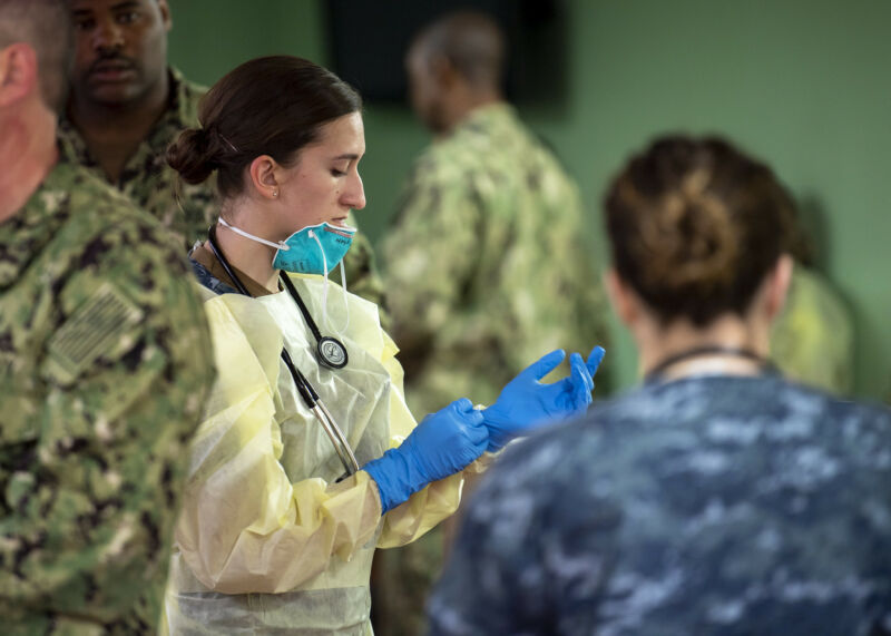 Hospital Corpsman 3rd Class Kimberly Wyss, from Ventura, Calif., dons surgical gloves aboard the hospital ship USNS <em>Mercy </em>(T-AH 19).