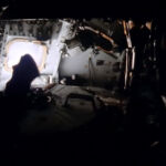 This image shows, in some detail, the dark, cold, powered-down command module Odyssey prior to the crew re-inhabiting the stricken spacecraft for the final critical part of the mission. Having been powered down since shortly after the explosion, a detailed start-up procedure was determined in order to conserve the little energy that was remaining in the CM's batteries. The large docking hatch is prominent in the image, and the detail in the instrument control panels is visible around the window.