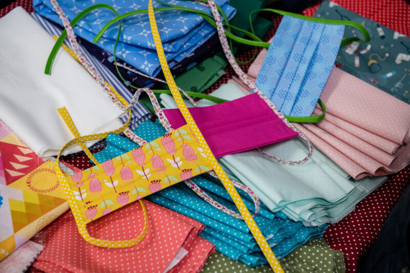 Colorful face masks are stacked on a table.