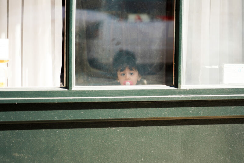 NEW YORK, NEW YORK - MARCH 24:  A child with a pacifier looks out a window as the coronavirus continues to spread across the United States on March 24, 2020 in New York City. The World Health Organization declared COVID-19 a global pandemic on March 11th. (Photo by Cindy Ord/Getty Images)