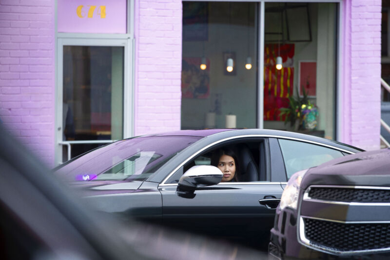 Promotional image of a Lyft driver waiting in her car.