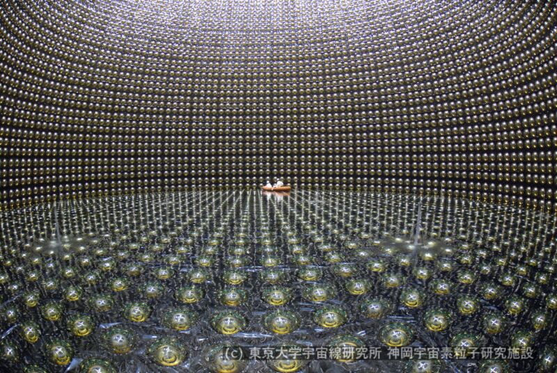 Image of a small raft floating in a giant tank covered in detectors.