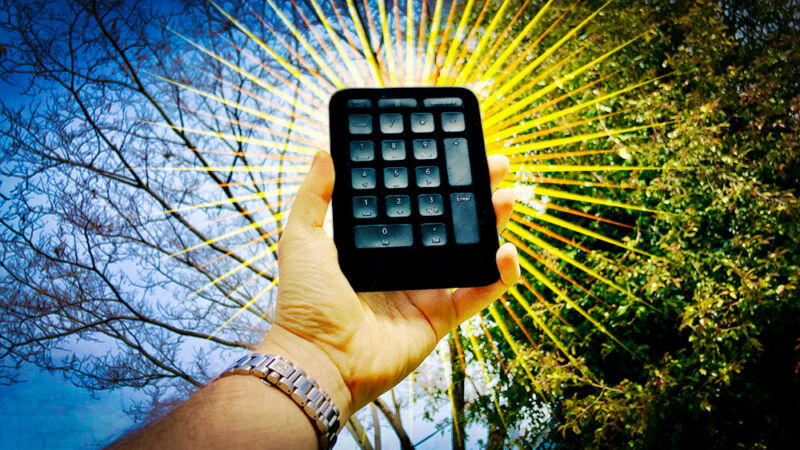 Stylized image of a hand holding a wireless 10-key pad.