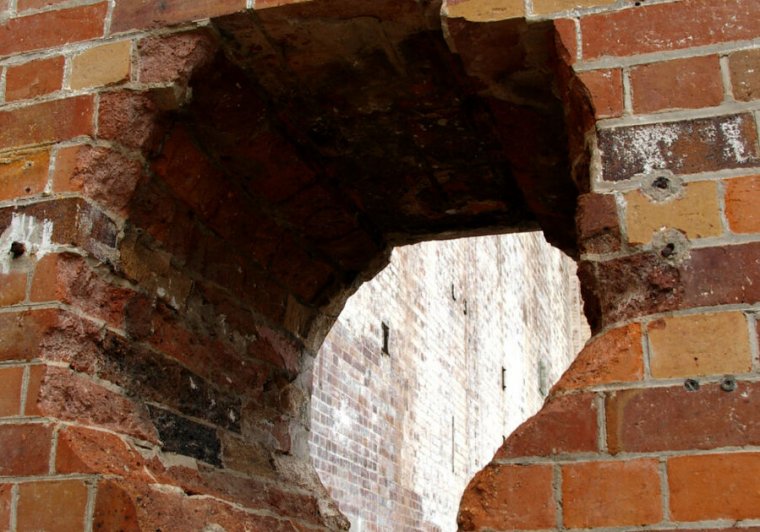 A gaping hole in a brick wall.