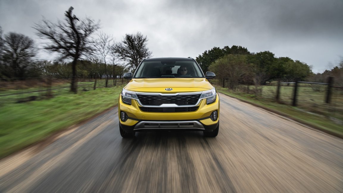 A yellow Kia Seltos drives towards the camera