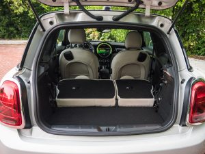 The rear of a Mini Cooper SE with the hatch open and the seats folded flat