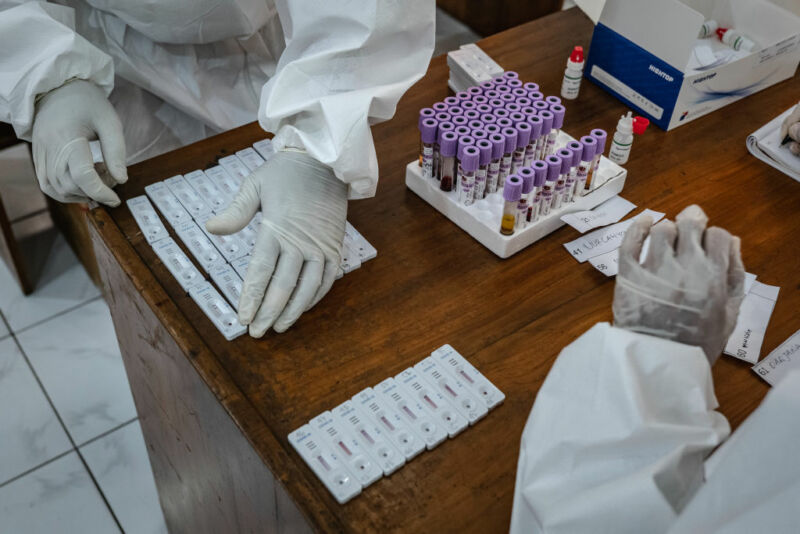 Image of gloved hands arranging blood samples.