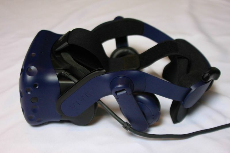 A virtual reality headset has been photographed on a white bedsheet.