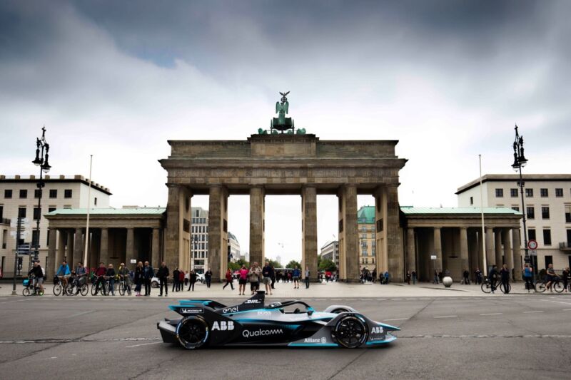 An electric race car on display in front of a German monument.