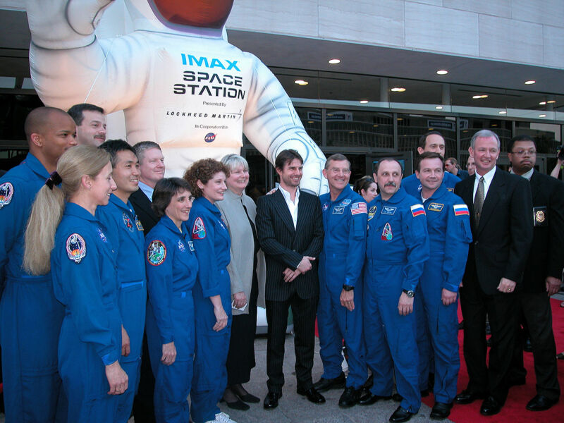 Tom Cruise, at center, poses with NASA astronauts at the 2002 premiere of the IMAX film <em>Space Station 3D</em> at the National Air and Space Museum in Washington, DC. From left to right: Robert Curbeam, Marsha Ivins, Koichi Wakata, Scott Altman, Nancy Currie-Gregg, Bill Shepherd, Susan Helms, IMAX producer Toni Myers, James Voss, Yuri Usachov, Yuri Lonchakov, Jim Newman and Brian Duffy.”><figcaption class=