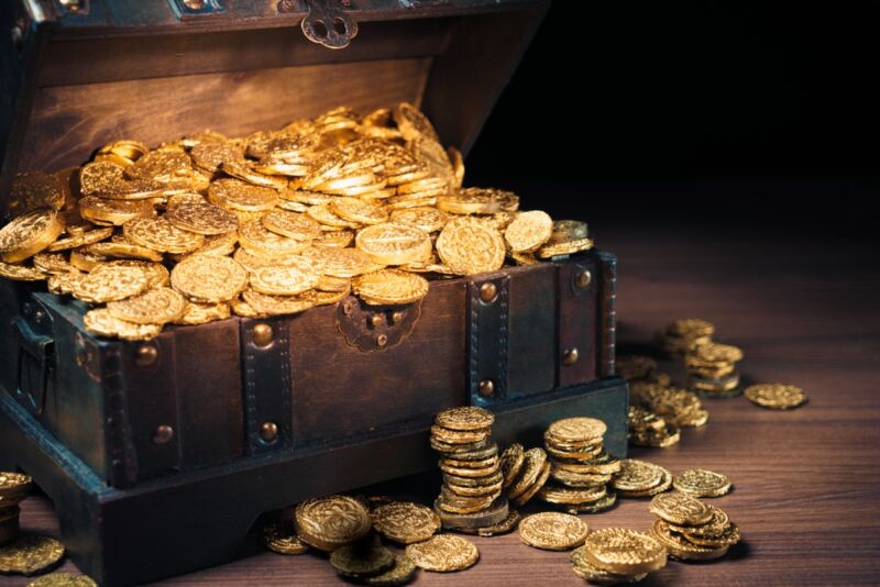 Stock photo of a stereotypical treasure chest overflowing with gold coins.