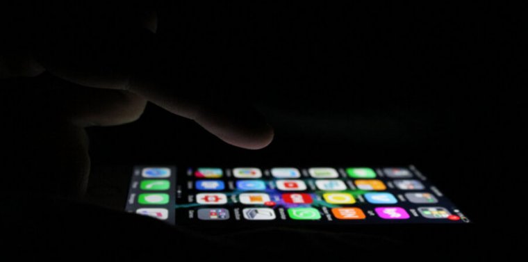 Stock photograph of a smartphone being used in the dark.