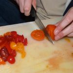 Image of someone slicing tomatoes.