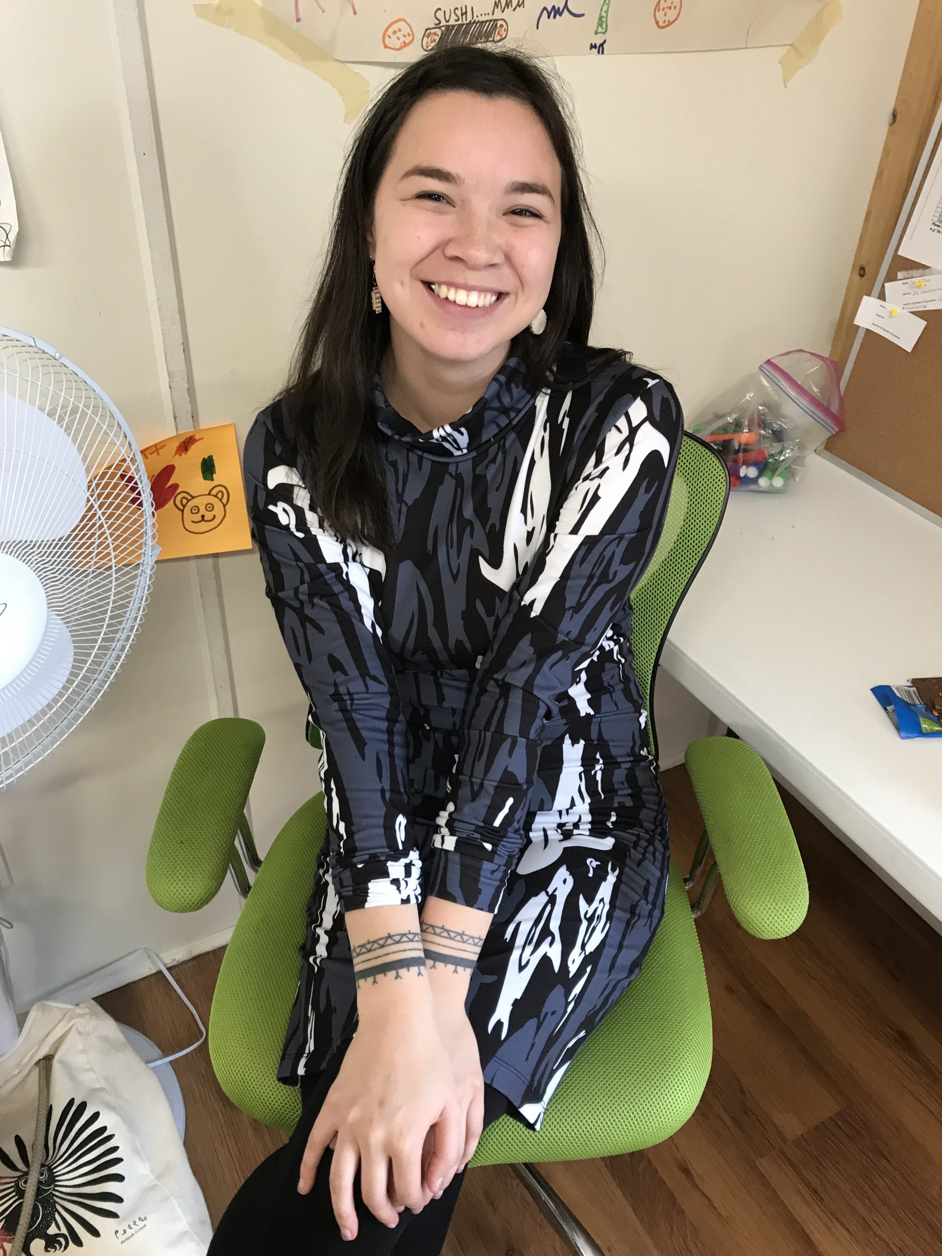 Image of a young woman seated on a desk chair.