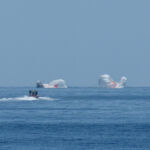 An image of the parachutes falling into the water.