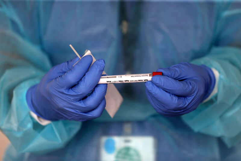 A nurse practitioner performs COVID-19 testing in the parking lot of Brockton High School in Brockton, MA under a tent during the coronavirus pandemic on August 13, 2020.