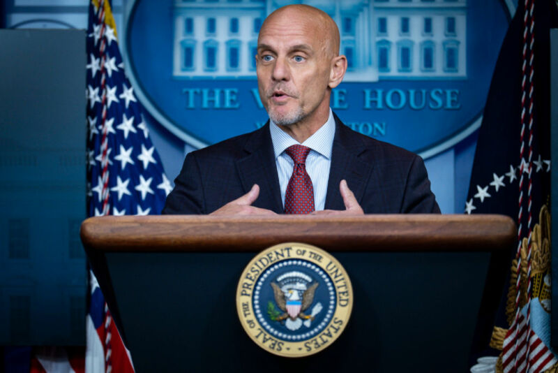 Image Of A Man Speaking From Behind A Podium.