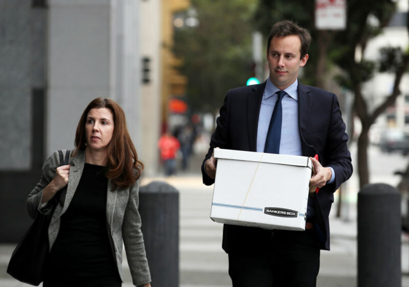 Anthony Levandowski walking to a courthouse while holding a cardboard box.