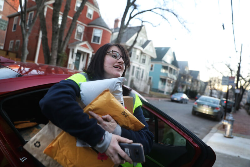 An Amazon Flex driver delivers an armload of packages in Cambridge, Mass., on Dec. 18, 2018. 