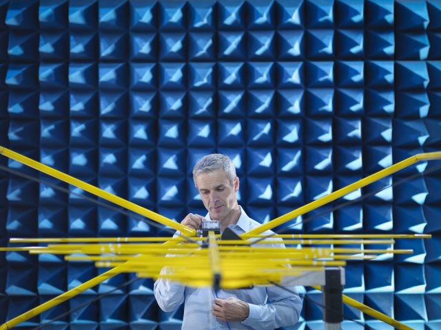 This person is doing electromagnetic testing in a special test chamber, similar to what National Instruments would use to test devices.