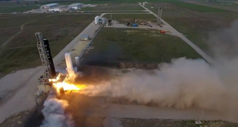Wide-angle view of a rocket liftoff from a grassy field.