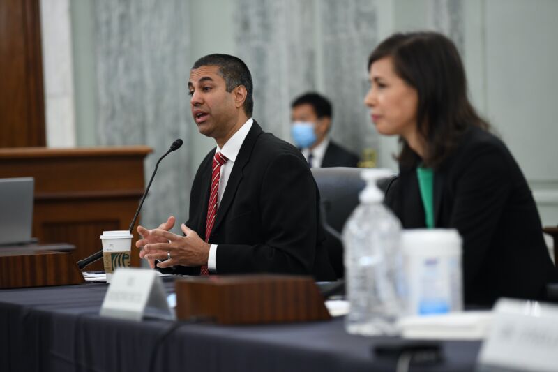 FCC Chairman Ajit Pai sitting at a table and speaking at a Senate hearing, with FCC Commissioner Jessica Rosenworcel also pictured.