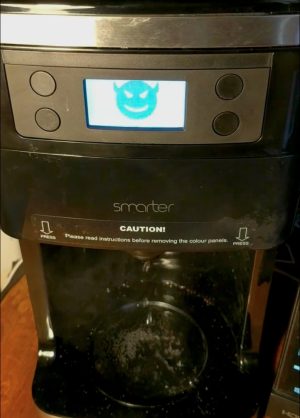 A demon face appears on the display of a high-tech coffee maker.