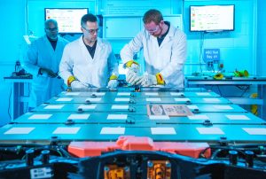 Workers assemble a battery pack at GM's battery lab.