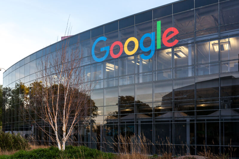 Multistory glass building with huge Google logo.