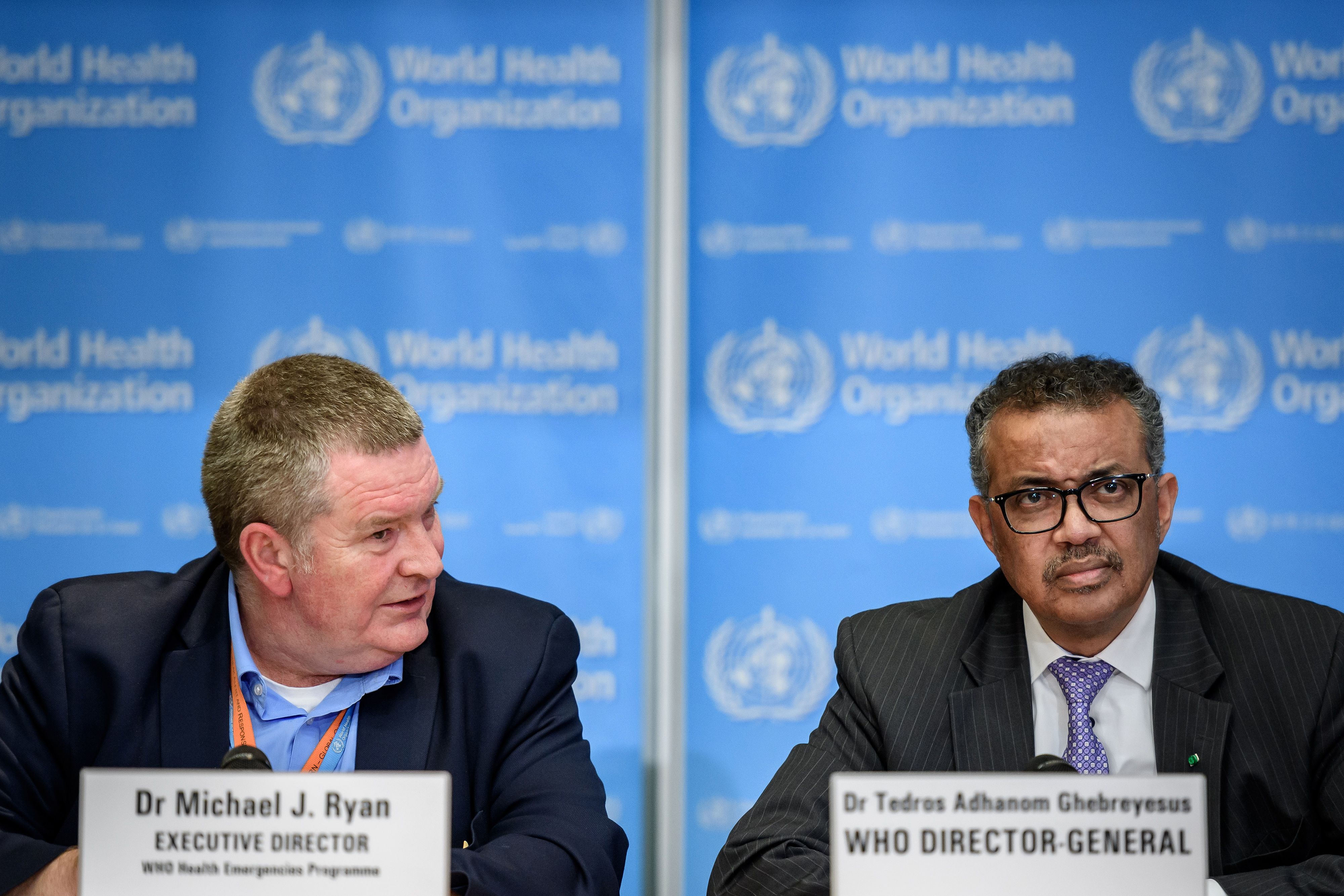 World Health Organization (WHO) Health Emergencies Program Director Michael Ryan (L) speaks past Director-General Tedros Adhanom Ghebreyesus during a daily press briefing on COVID-19 virus at the WHO headquarters in Geneva on March 9, 2020. 